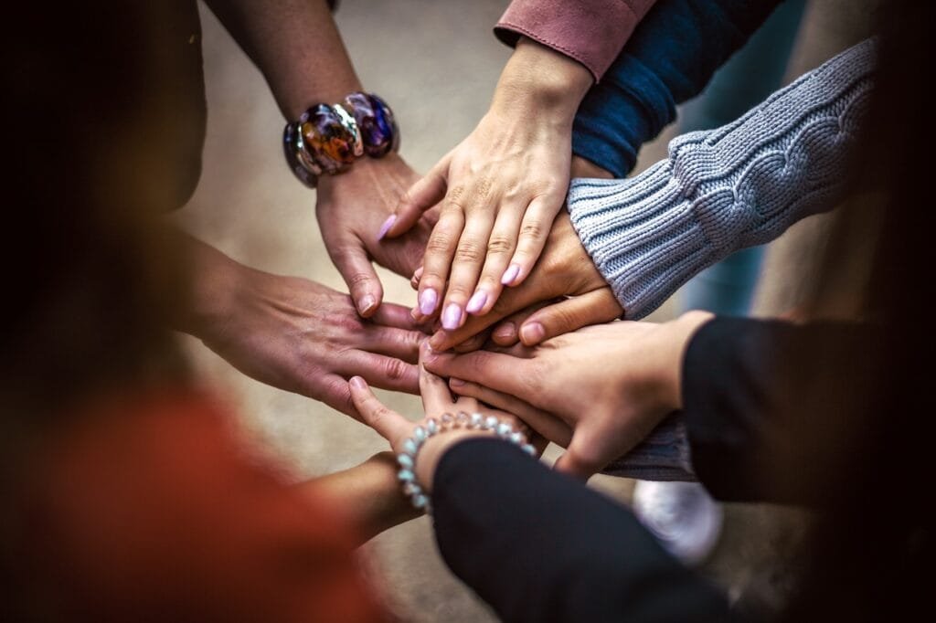 7 mãos unidas em círculo