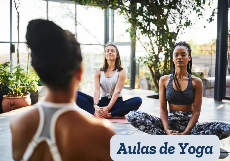 mulher ministrando aula de yoga para duas mulheres