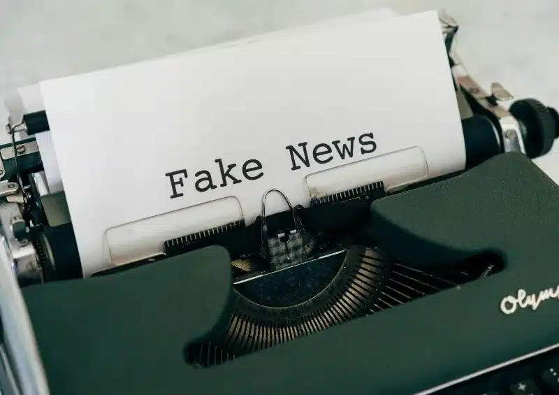 máquina de escrever com papel escrito fake news