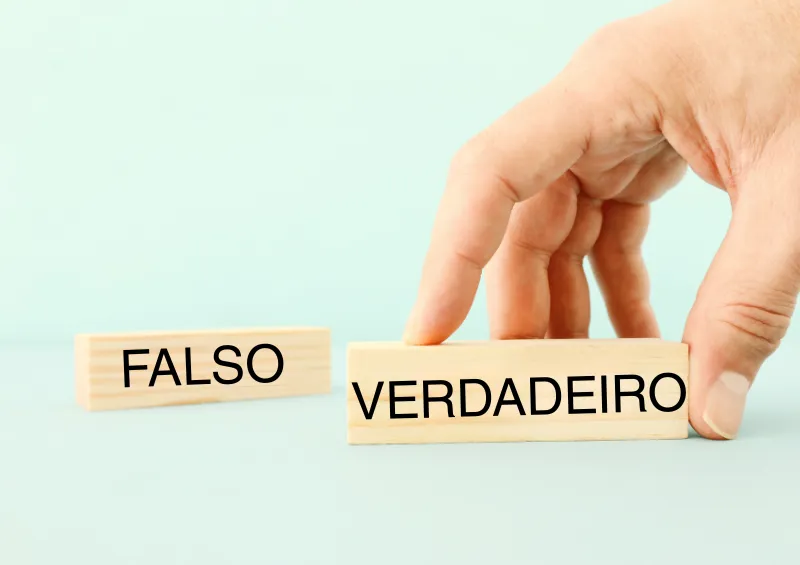 mão branca com blocos escritos falso e verdadeiro