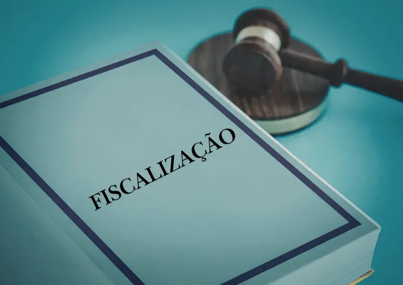bloco de papéis com a capa escrita fiscalização e martelo do juiz ao lado