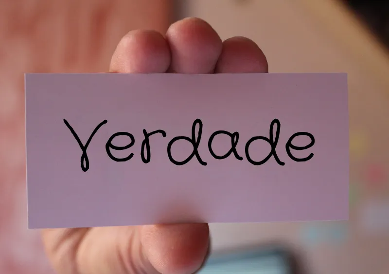 mão branca com papel escrito verdade